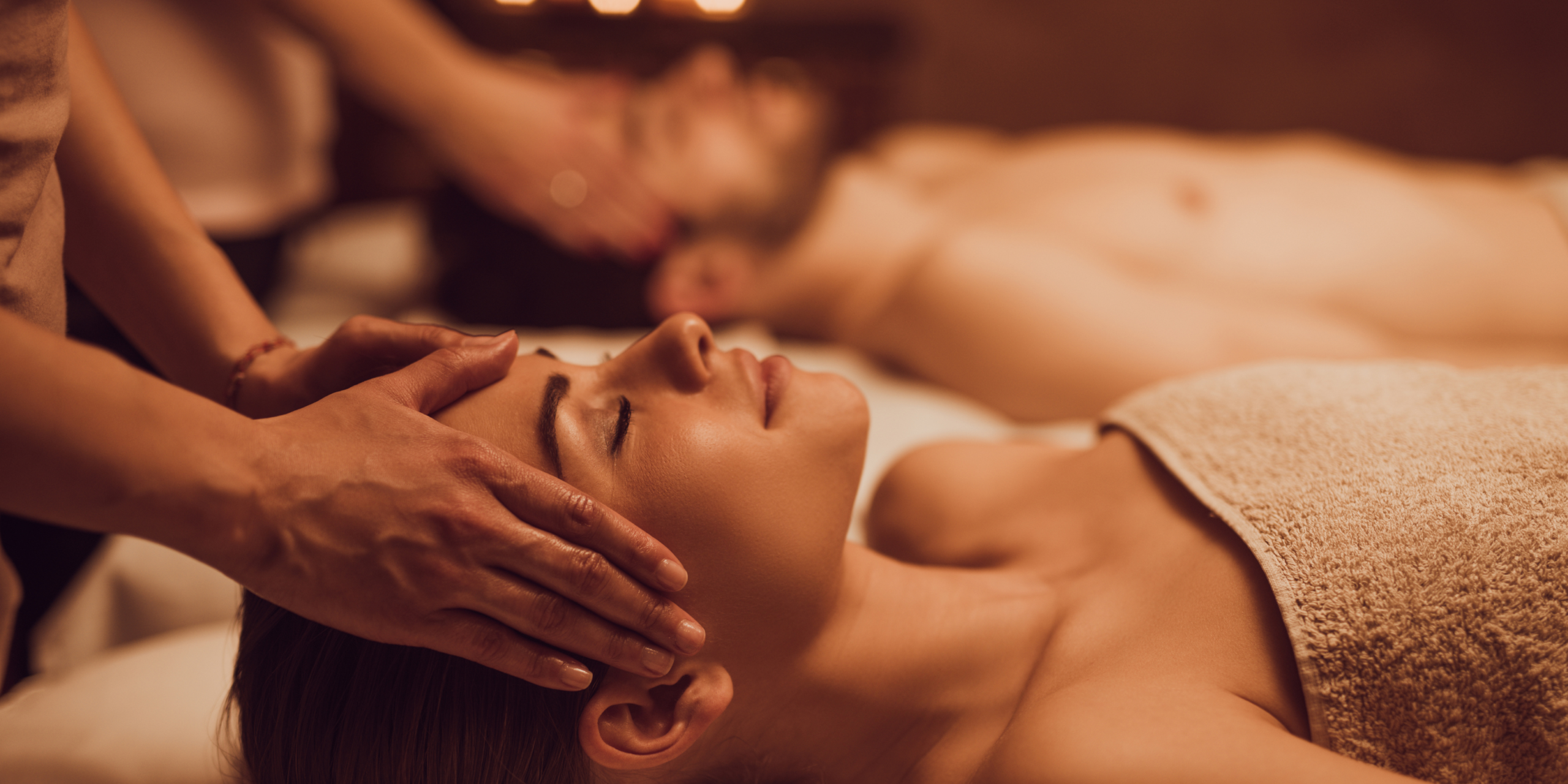 Massage of member's head. we see there head and the masseuse hands. Couple enjoying the offers